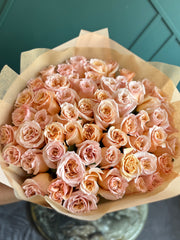 Luxury bouquet of 50 fresh peach roses beautifully wrapped by Luxury Flowers Miami