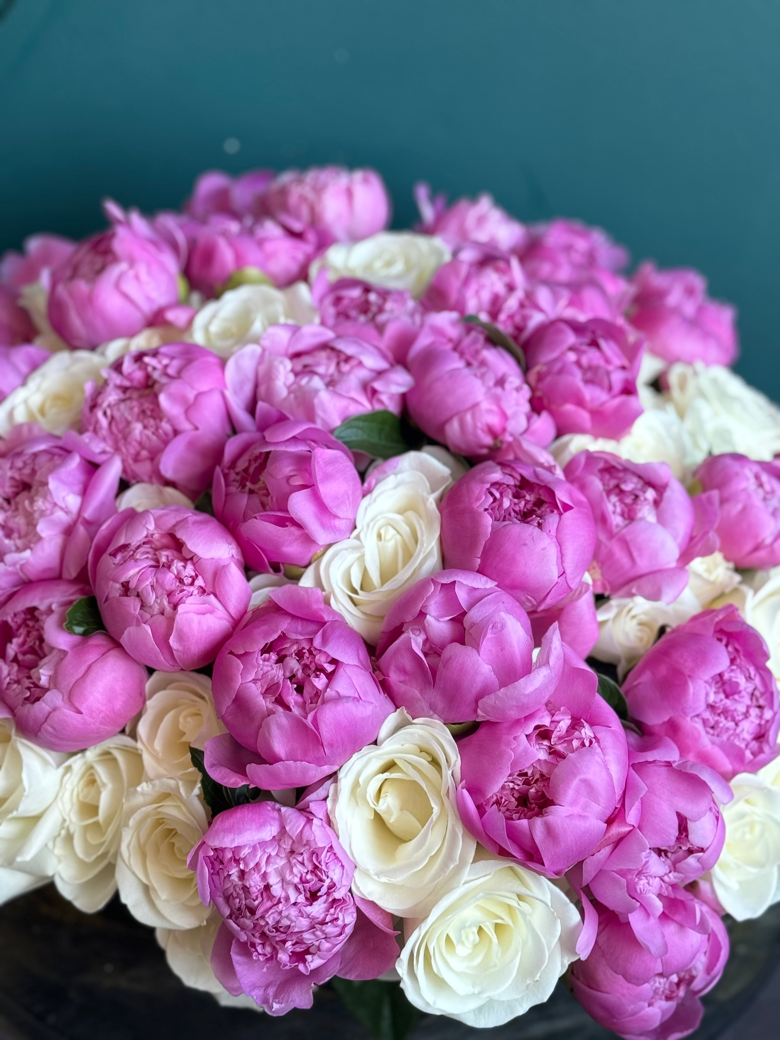 Luxury flower arrangement in cement vase with roses and peonies
