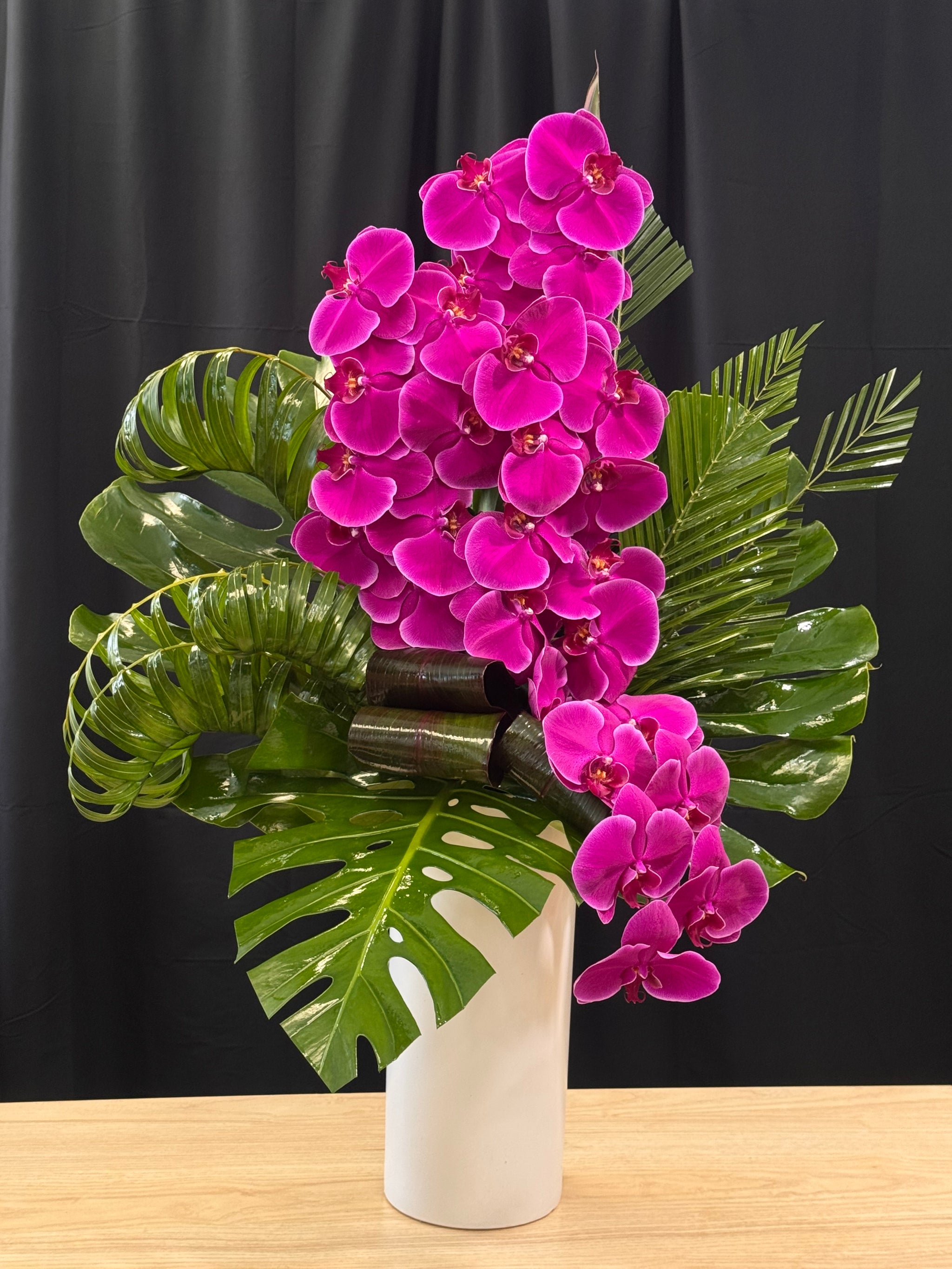 Luxury orchid arrangement with purple phalaenopsis and designer greenery