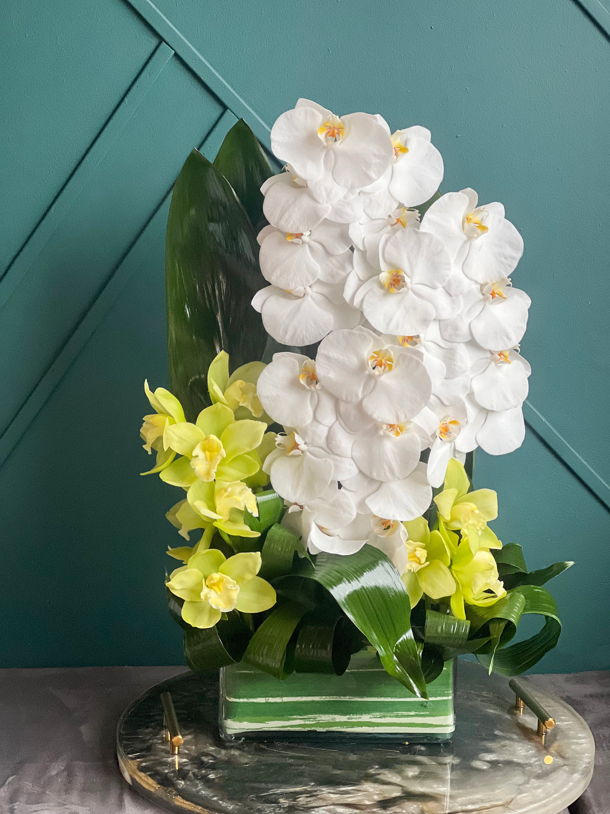 Luxury white orchid arrangement with green orchids in glass vase