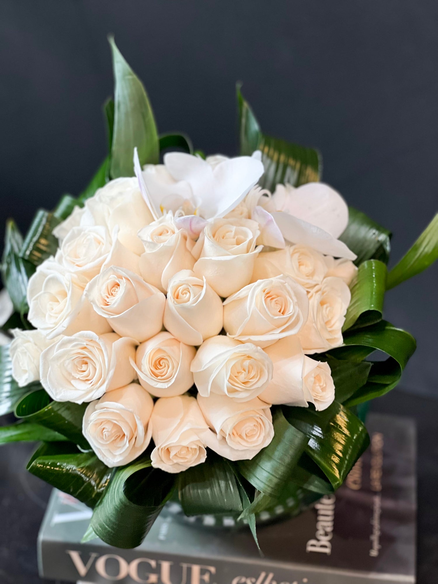 Luxury white rose arrangement in a round glass vase by Luxury Flowers Miami