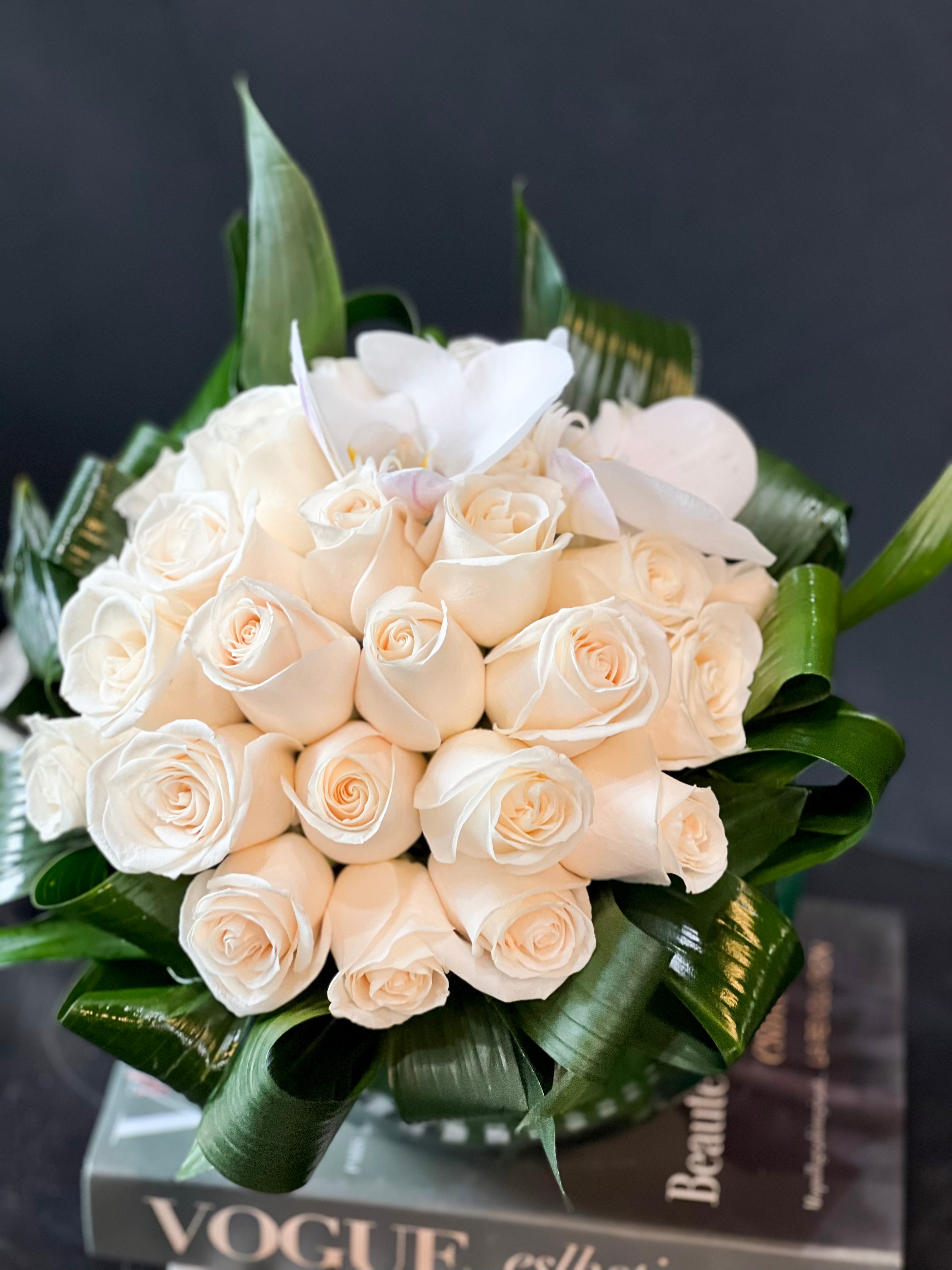 Luxury white rose arrangement in a round glass vase by Luxury Flowers Miami