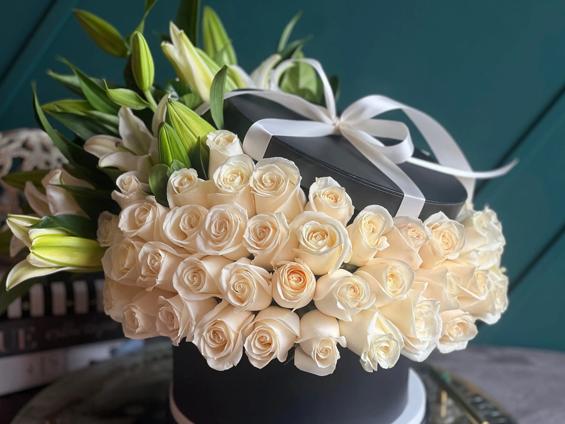 Luxury white roses and fragrant lilies in a black flower box in Miami