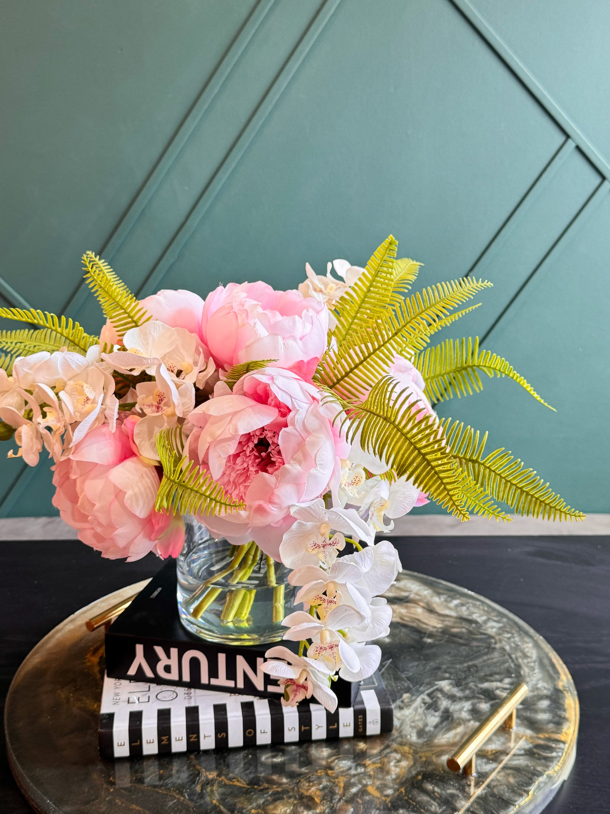 Maintenance-free floral arrangement in a clear glass vase for coffee tables, dining rooms, and entryways.