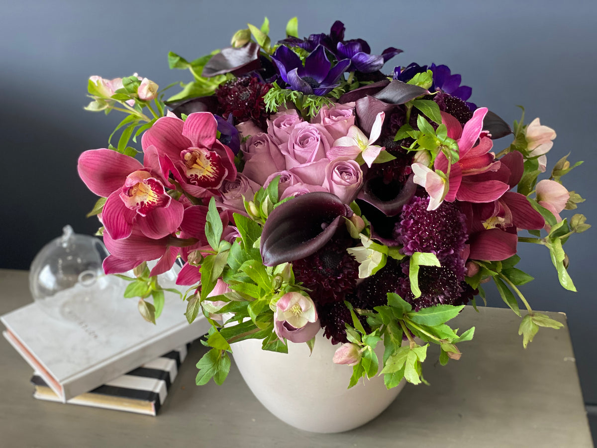 Modern purple flower arrangement in decorative vessel