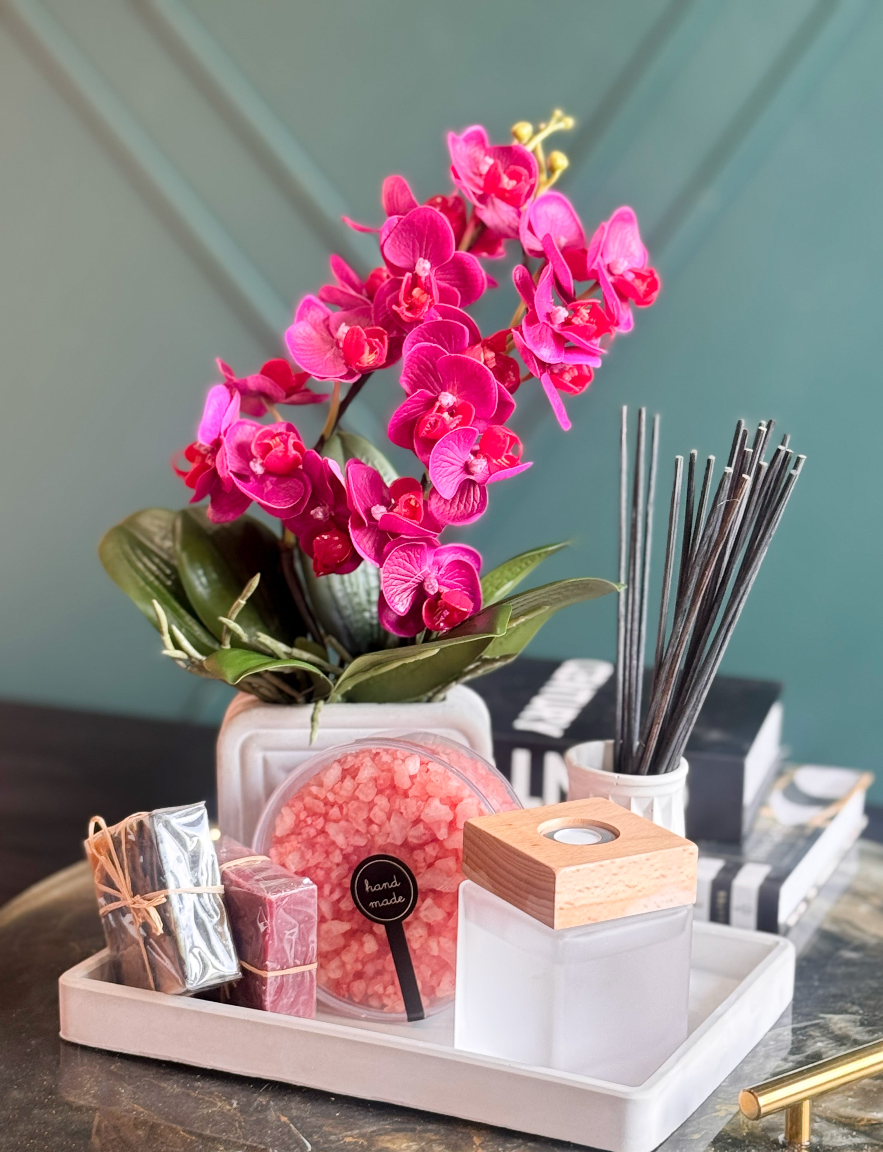 Modern self-care gift set with artificial orchid, scented bath salts, handmade soap and reed diffuser.
