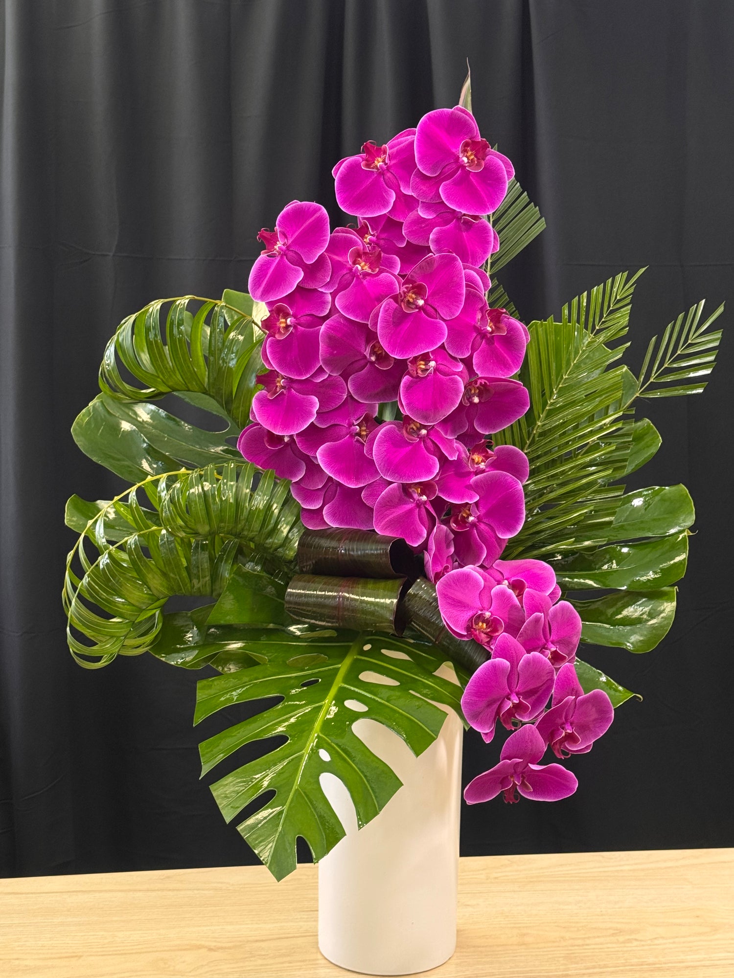 Modern tropical flower arrangement with purple phalaenopsis orchids