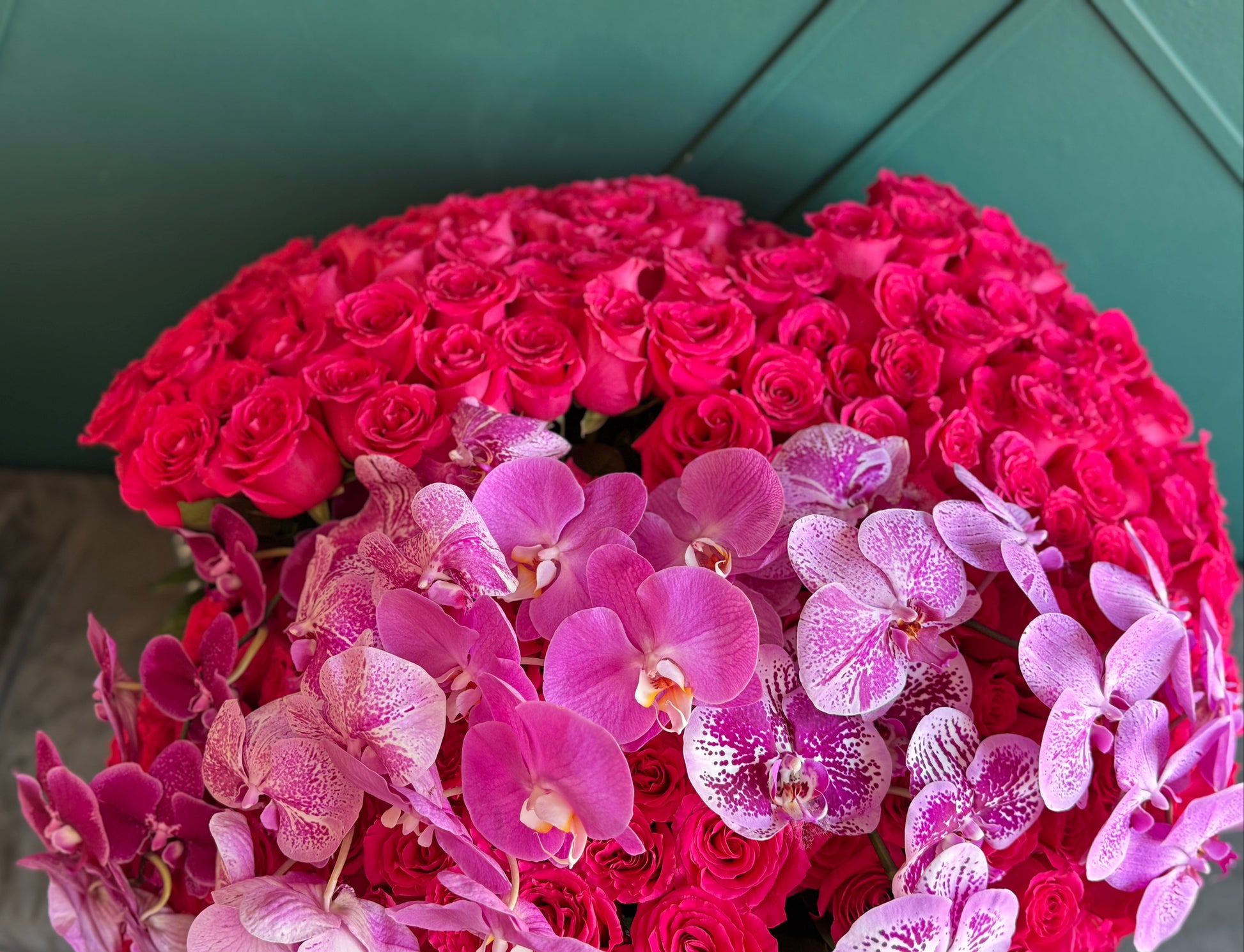 Oversized hot pink rose arrangement with cascading pink orchids