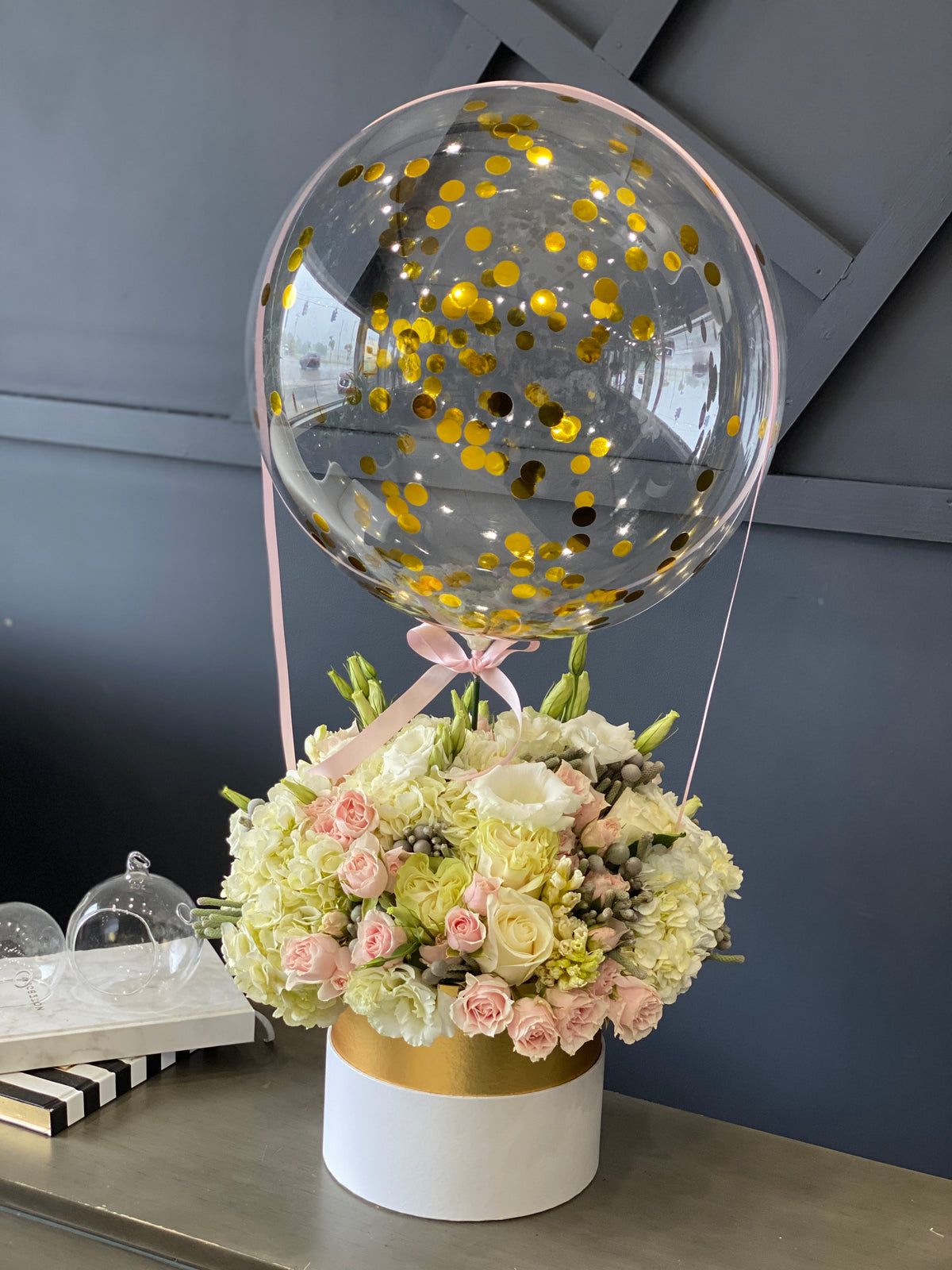 Pastel flowers in a box with clear balloon on top