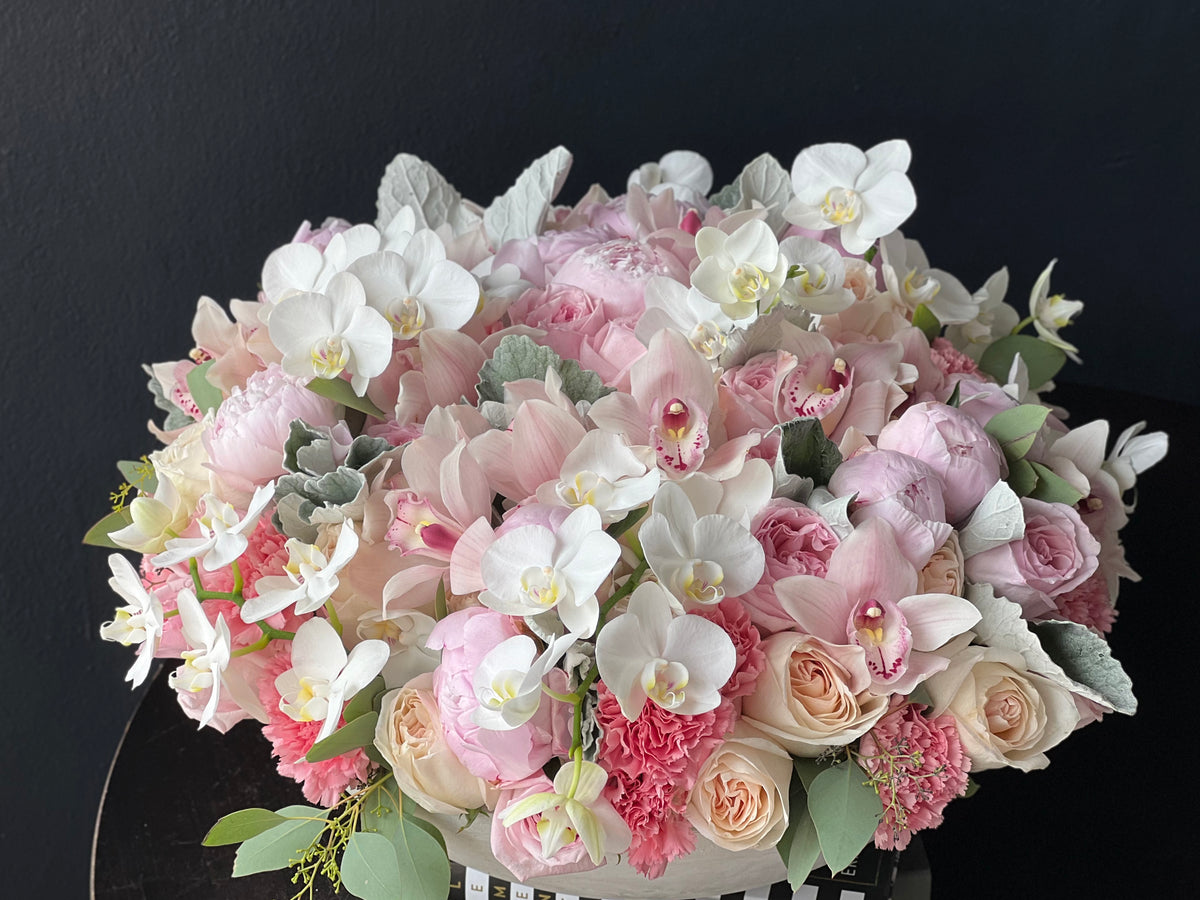 Pastel roses peonies and orchids in handcrafted cement bowl