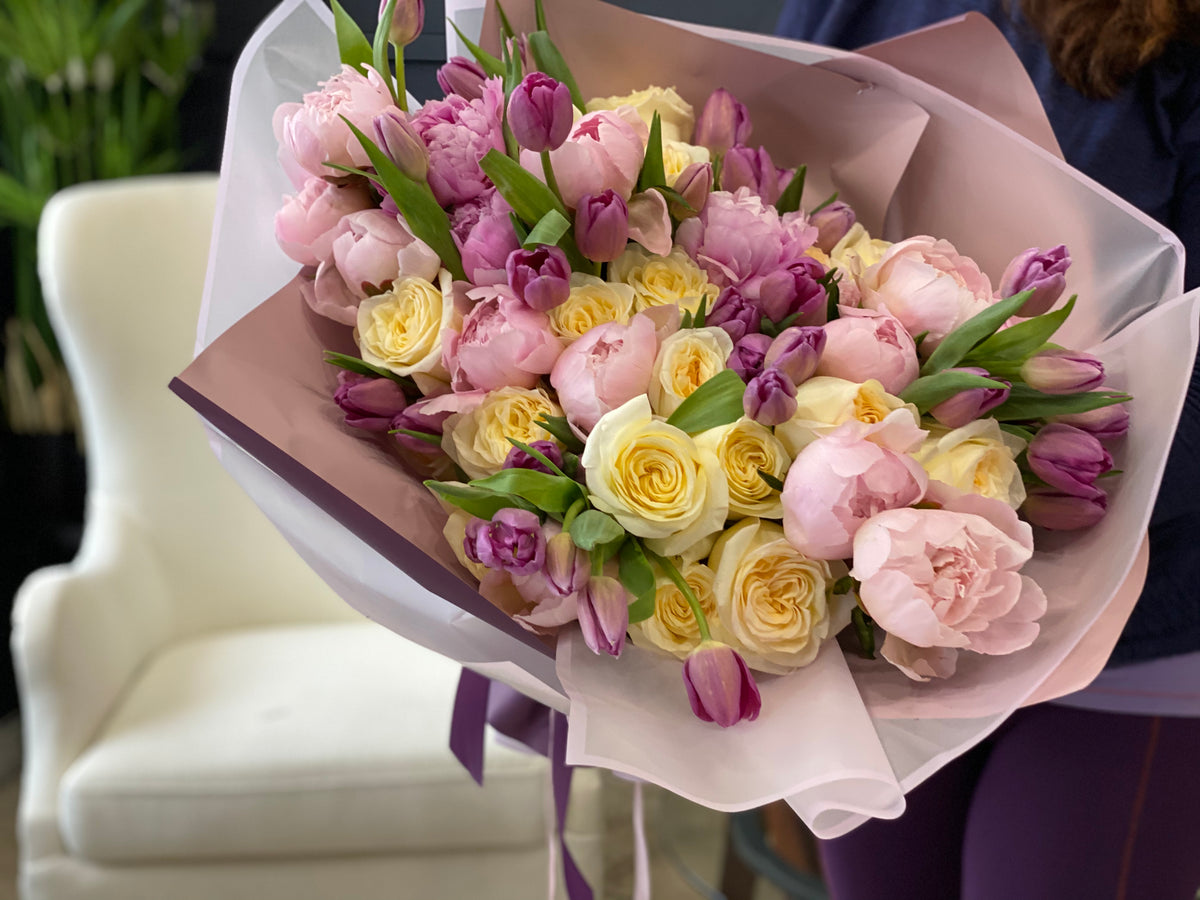 Pastel roses peonies and tulips wrapped flower bouquet