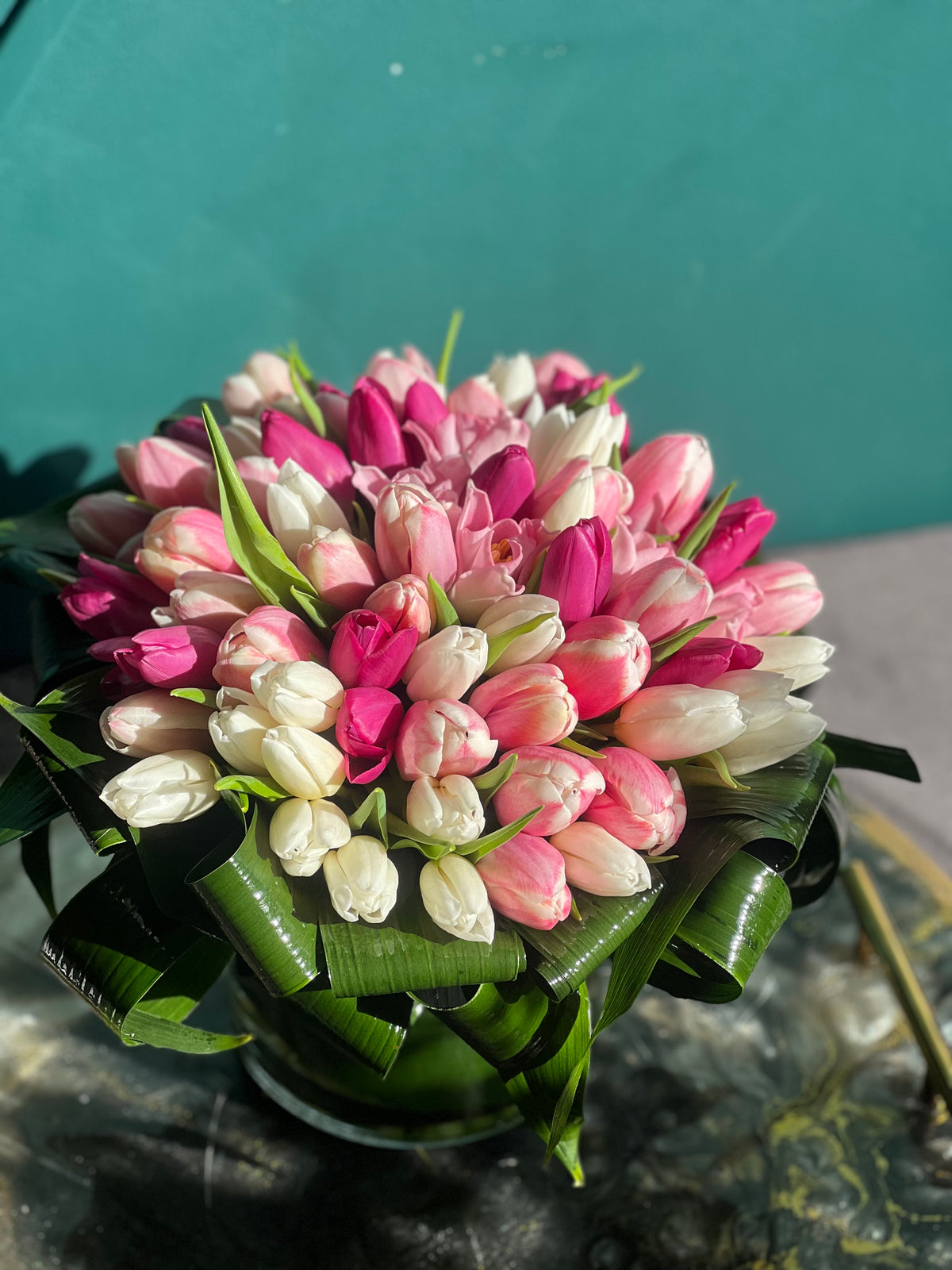 Pink and white tulip arrangement in glass vase
