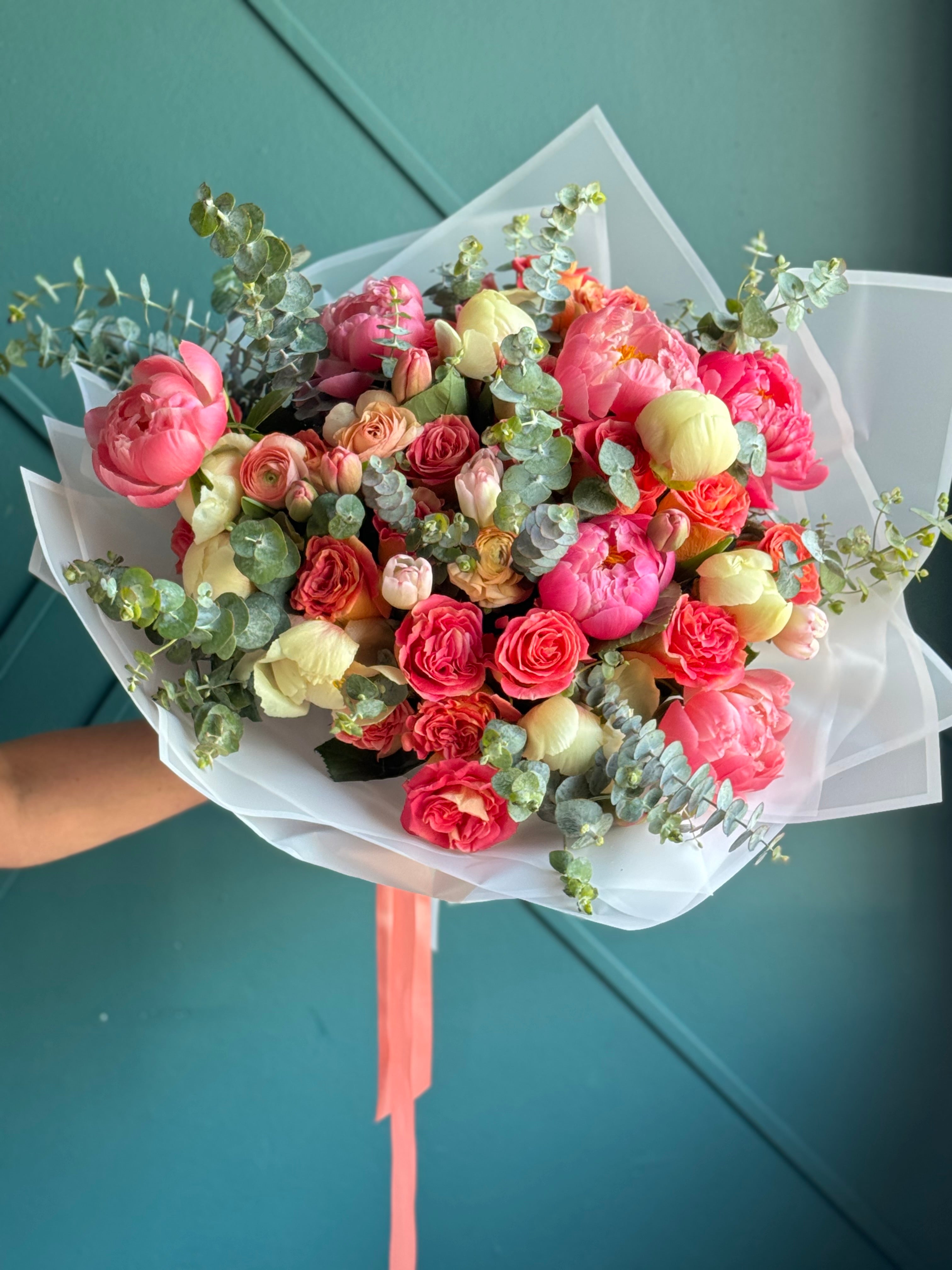 Pink and yellow peonies with garden roses and eucalyptus