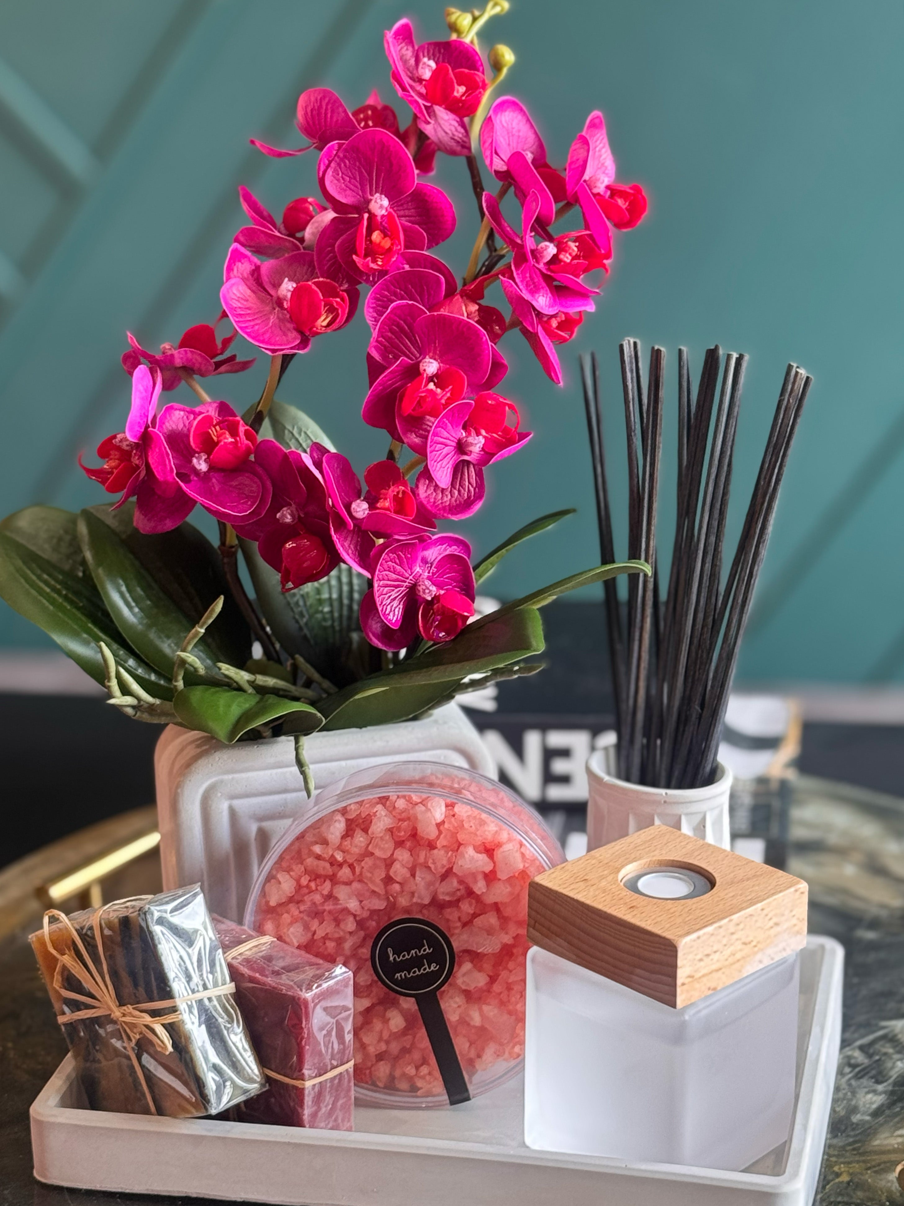 Premium wellness gift set with pink orchid arrangement, bath products and home fragrance diffuser.