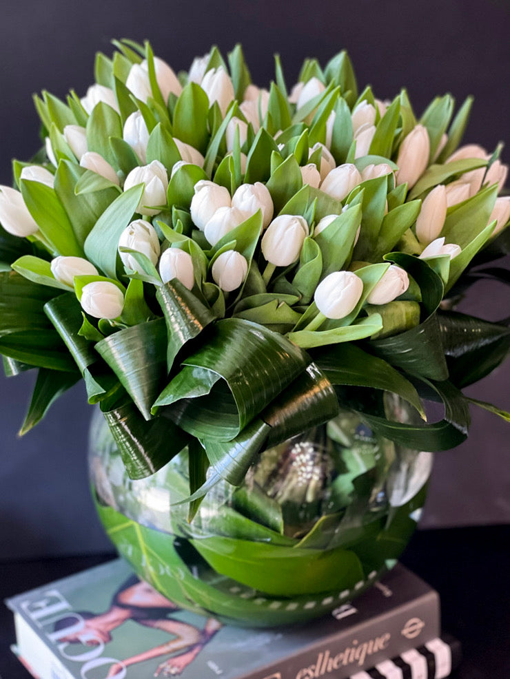 Premium white tulips in round glass vase