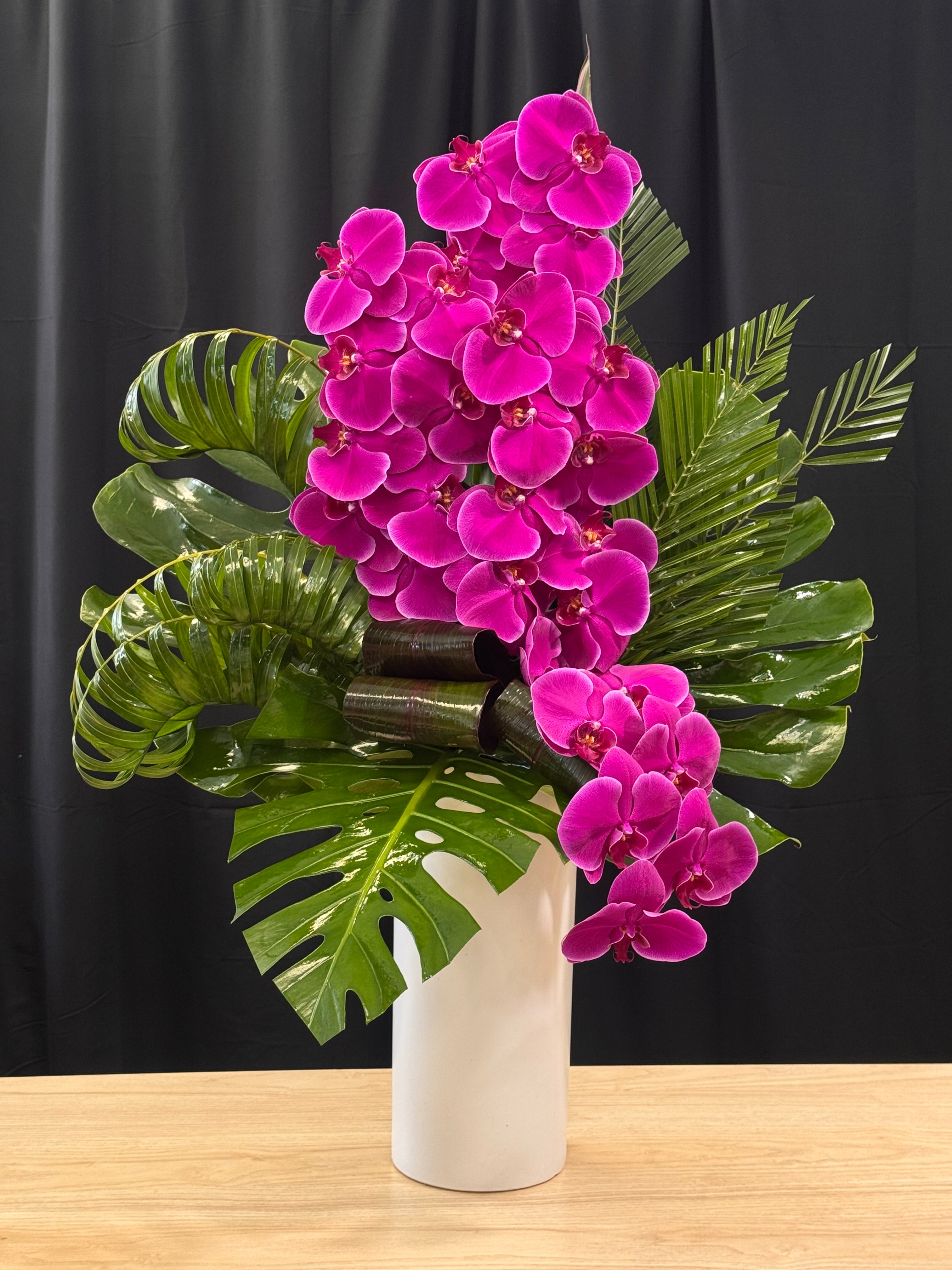 Purple phalaenopsis orchid arrangement with designer greenery by Luxury Flowers Miami