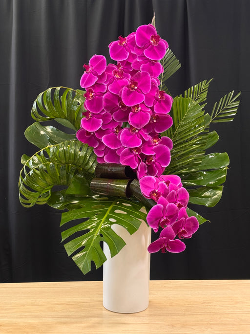 Purple phalaenopsis orchid arrangement with designer greenery by Luxury Flowers Miami