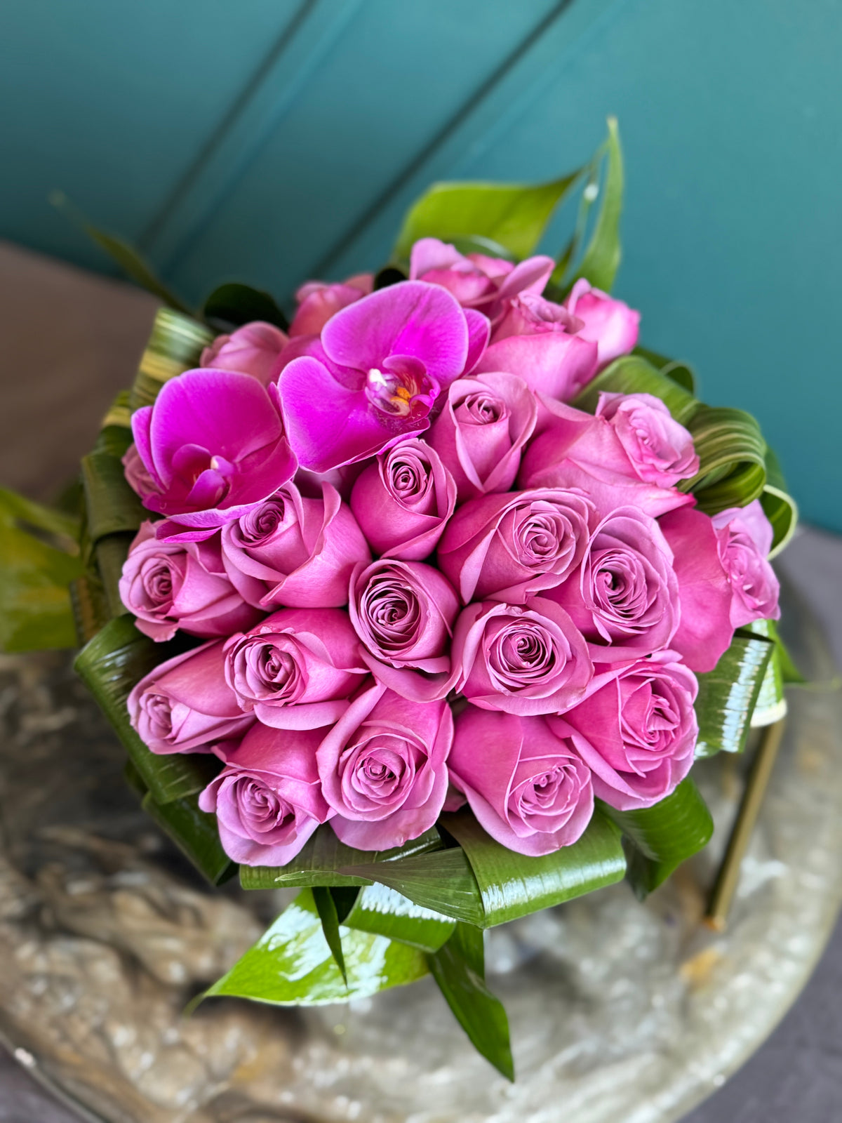Purple roses centerpiece in round fishbowl vase