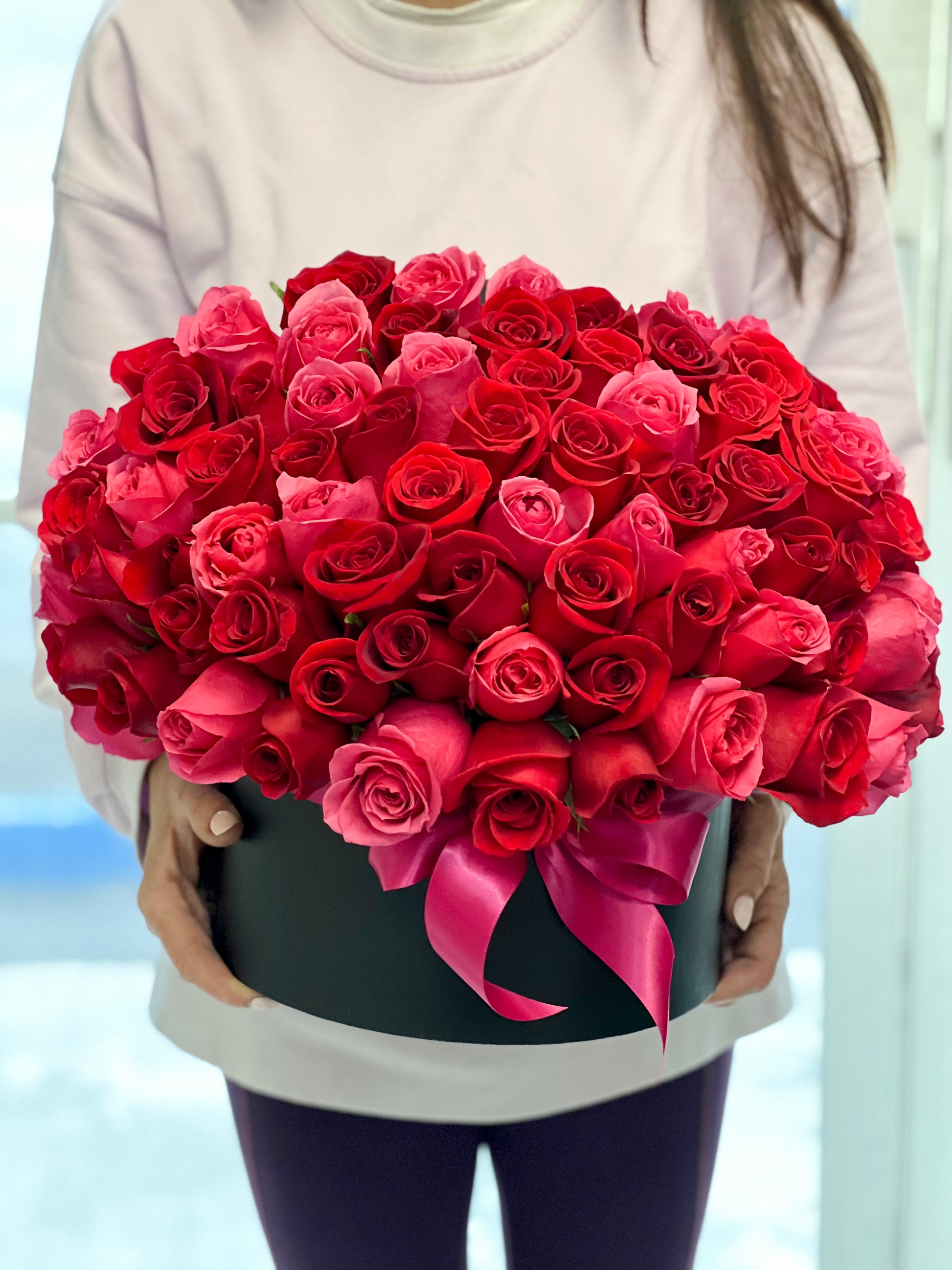 Red and hot pink roses arranged in a luxury flower box