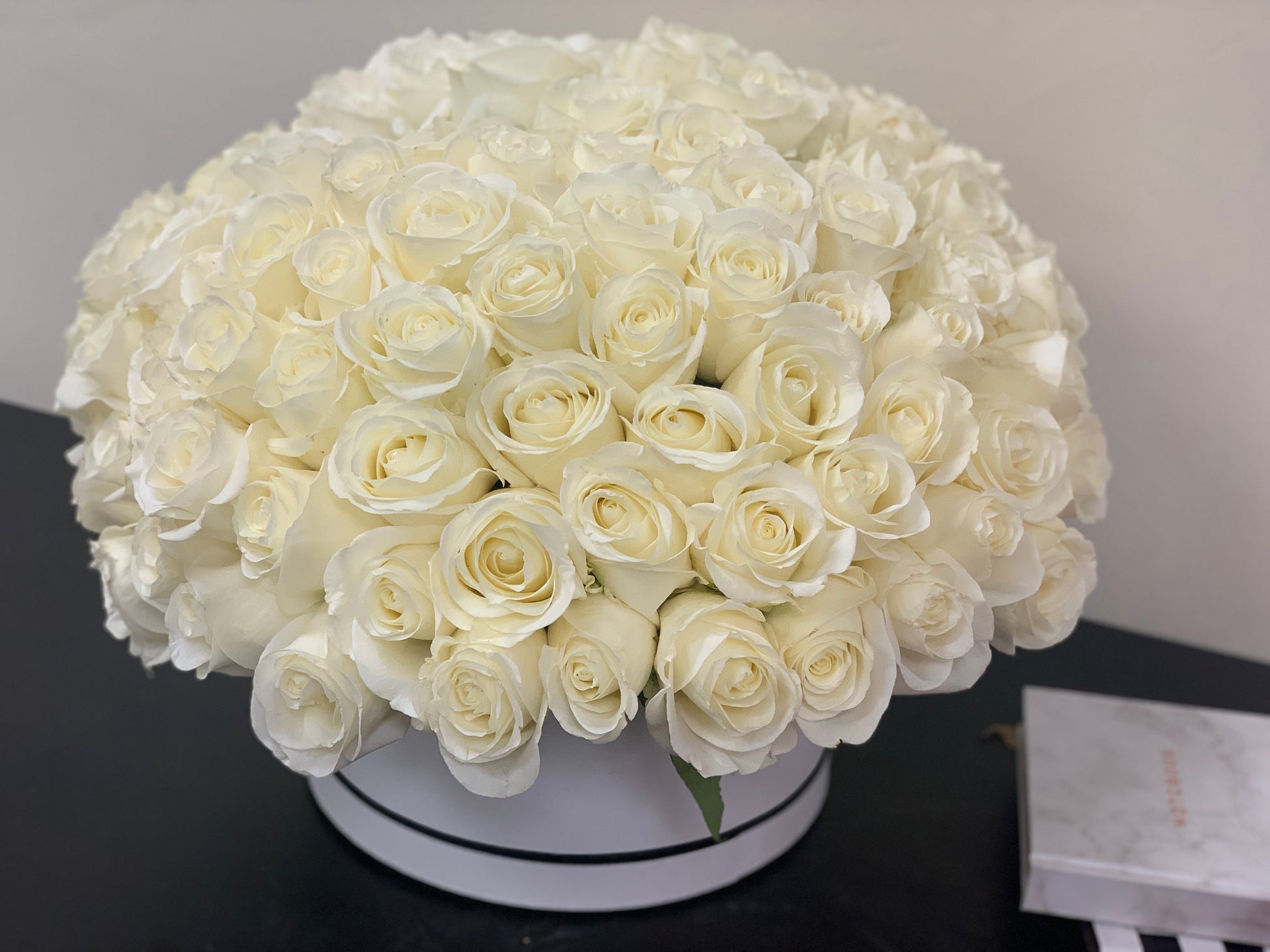 Round luxury box filled with 100 white roses for flower delivery in Miami