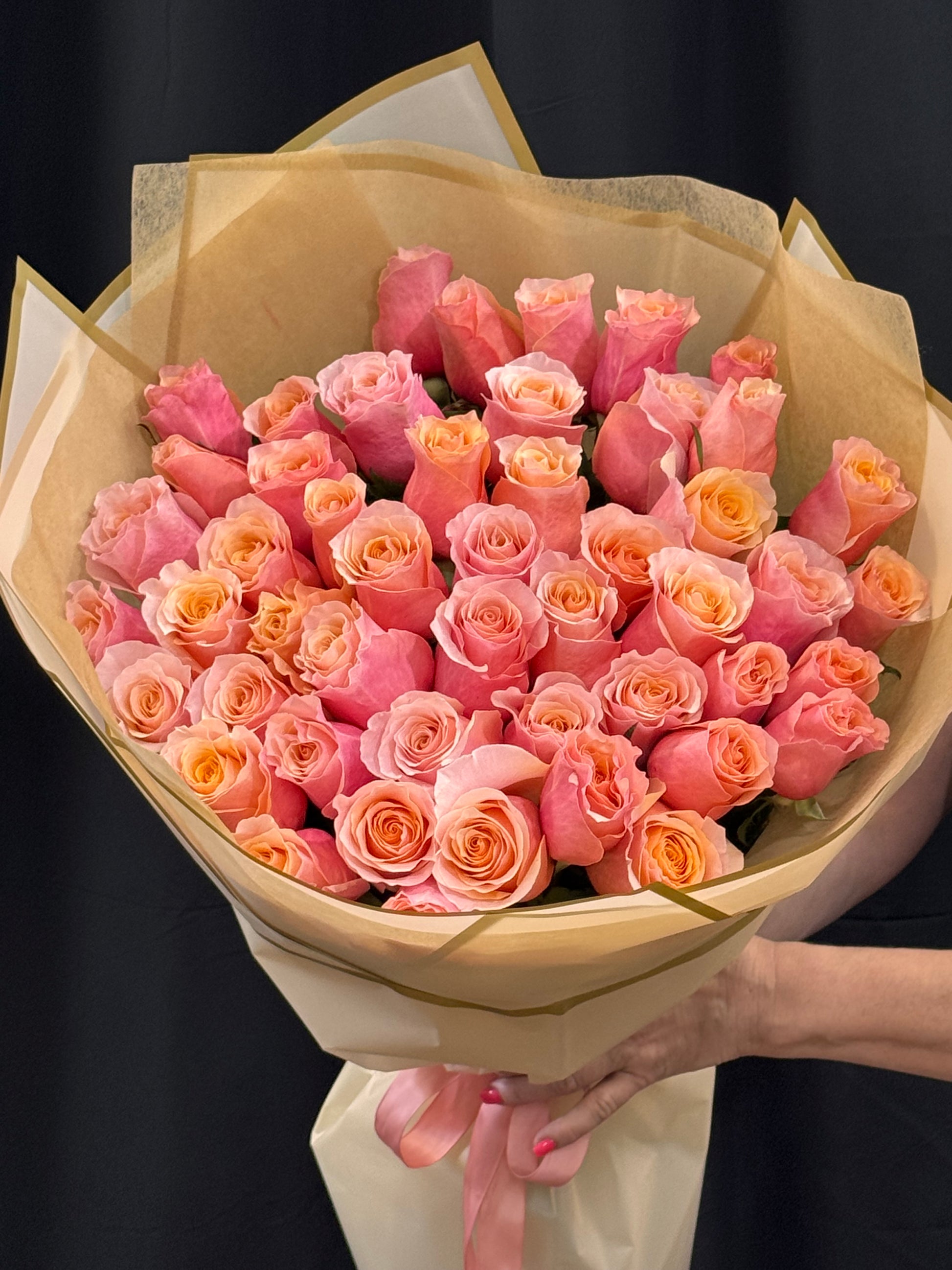 Soft coral and blush roses wrapped in premium floral paper