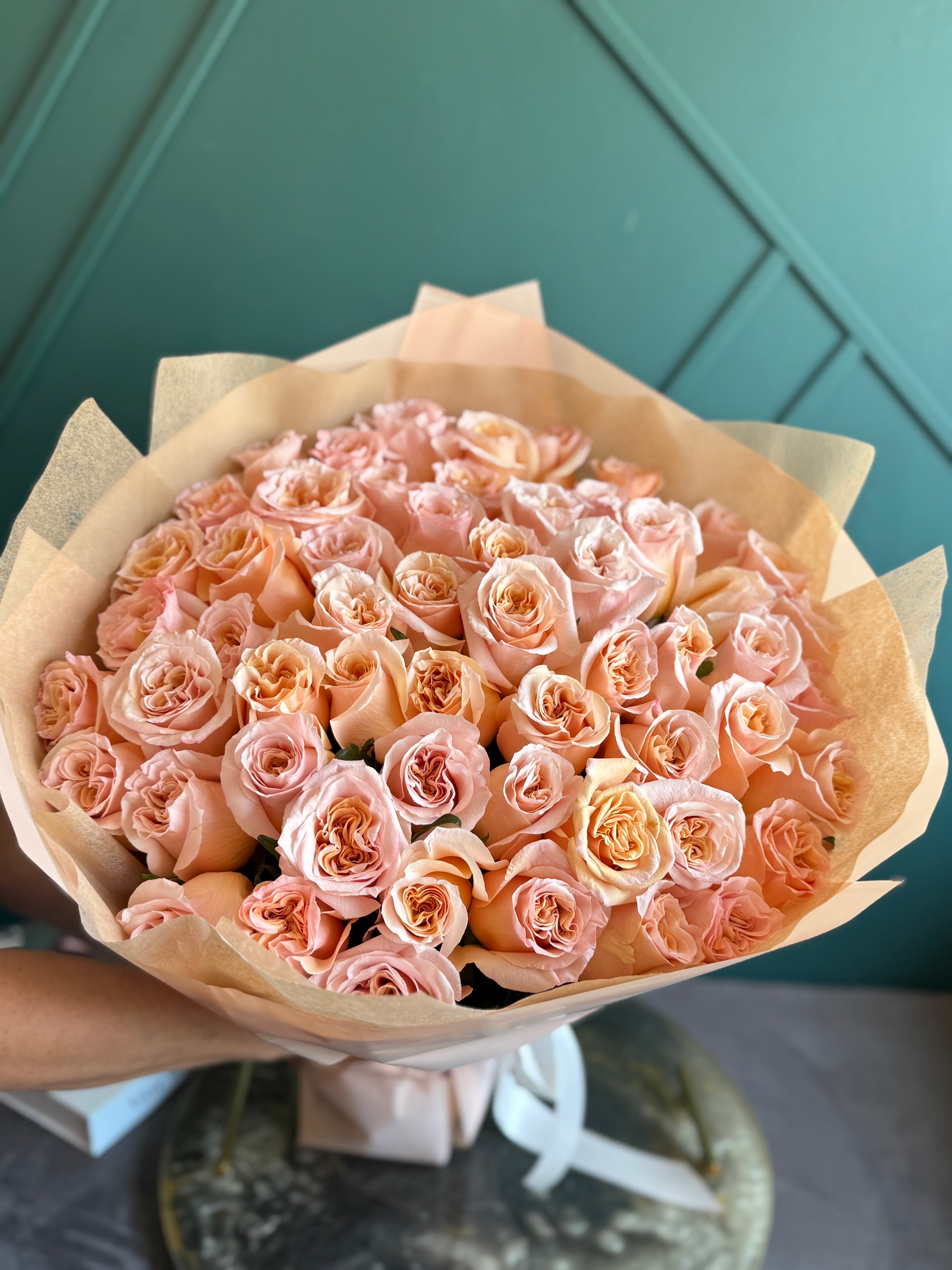 Soft peach roses wrapped in premium floral paper for a luxury gift