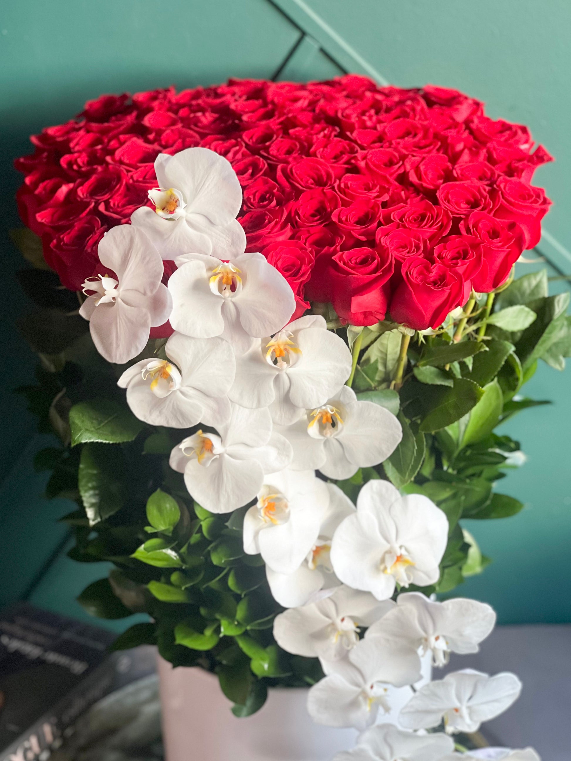 Tall arrangement of 100 premium red roses and Phalaenopsis orchids