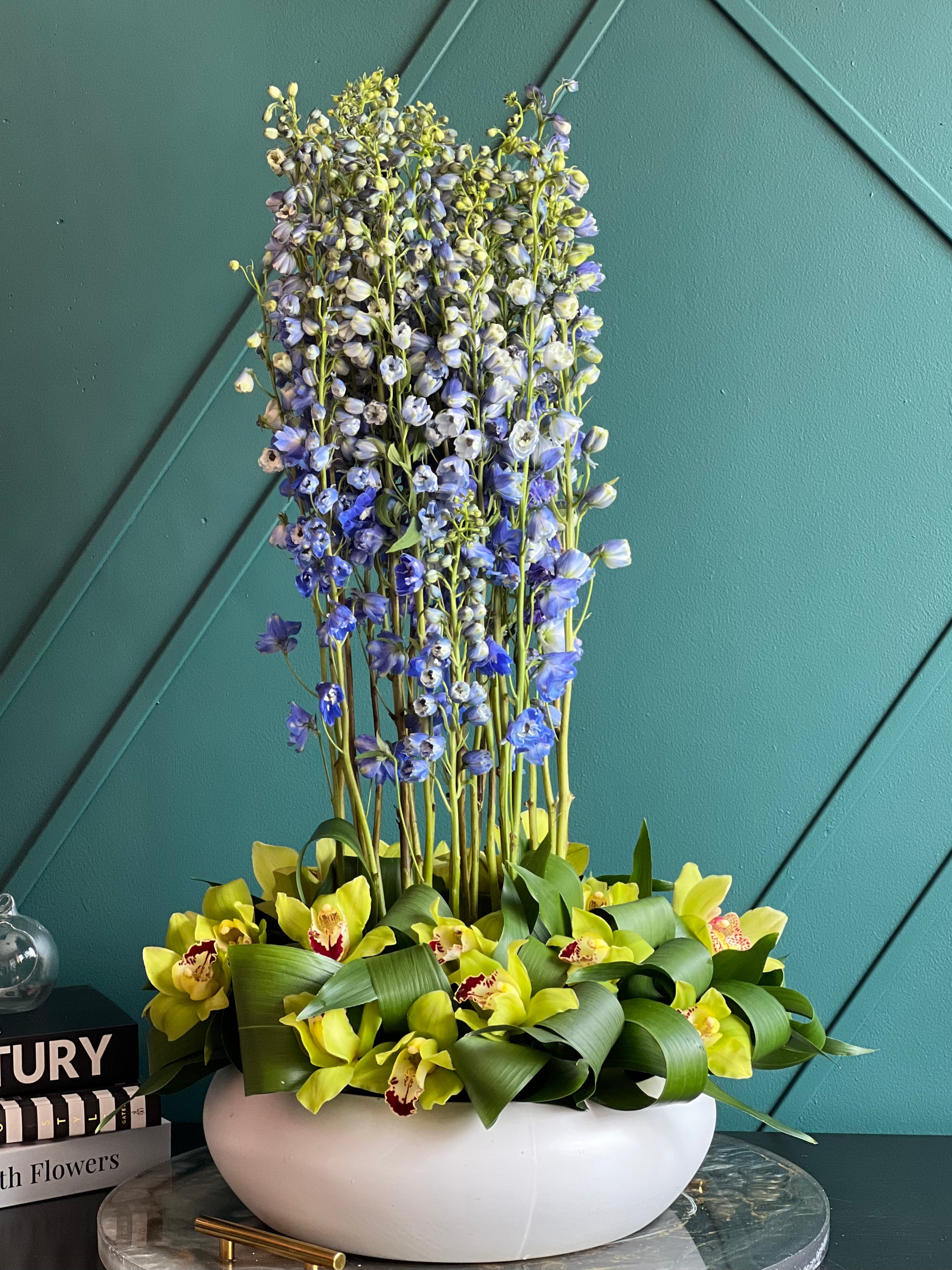 Tall delphinium arrangement with green cymbidium orchids