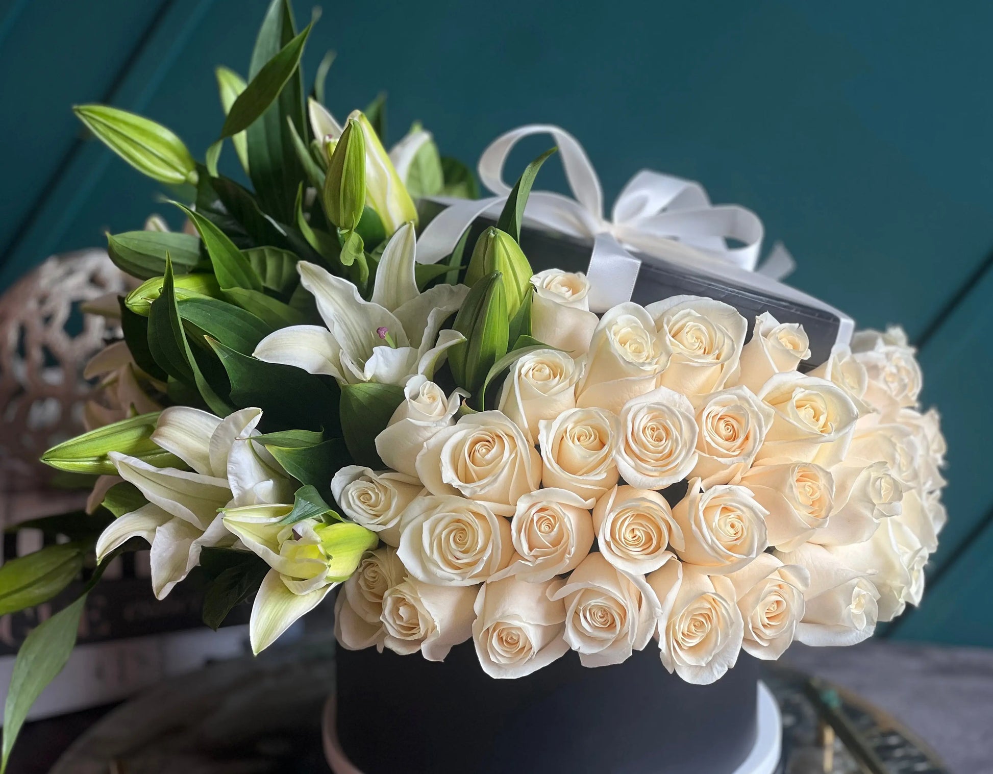White roses and beautiful fragrant lilies arranged in a luxury black box