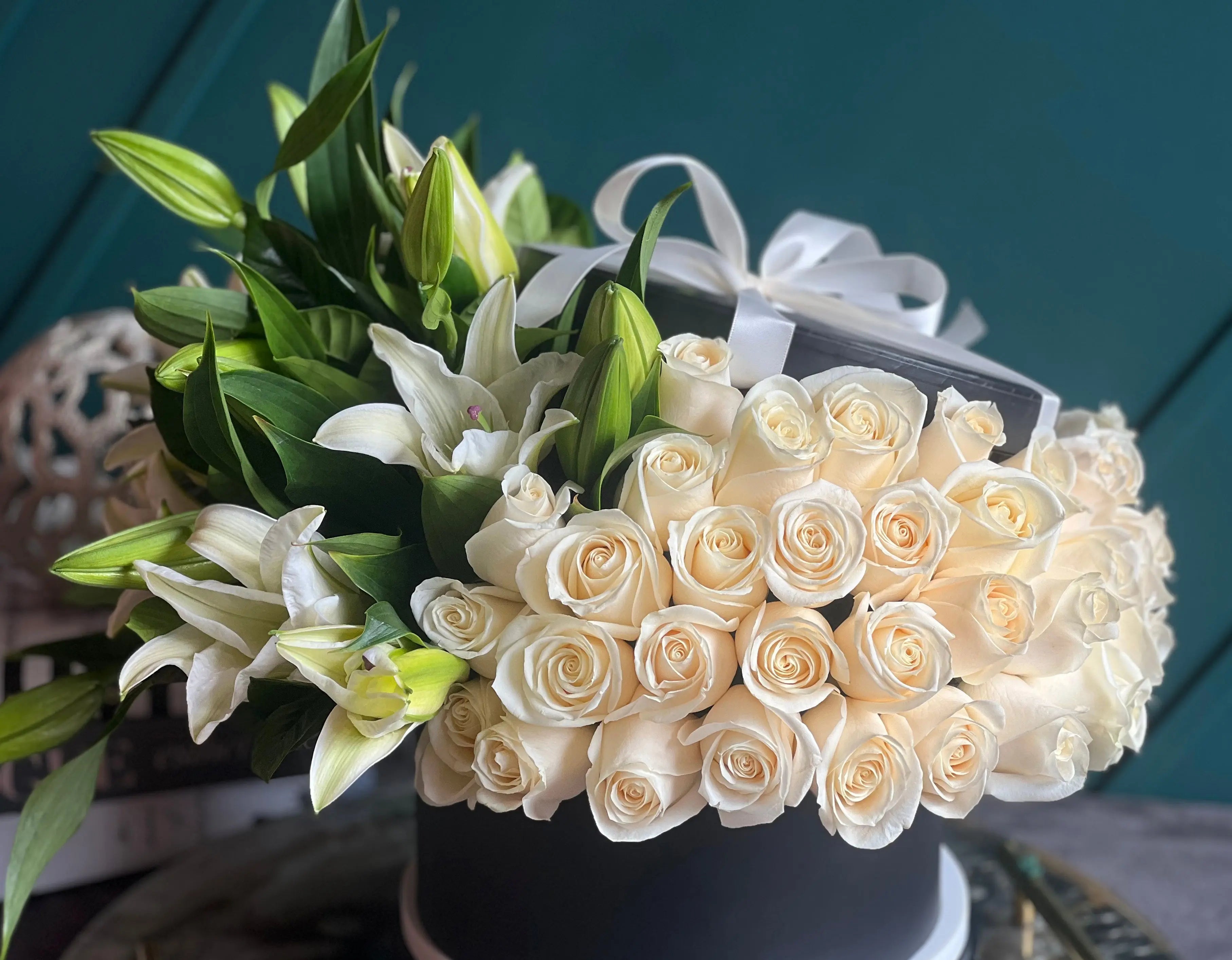 White roses and beautiful fragrant lilies arranged in a luxury black box