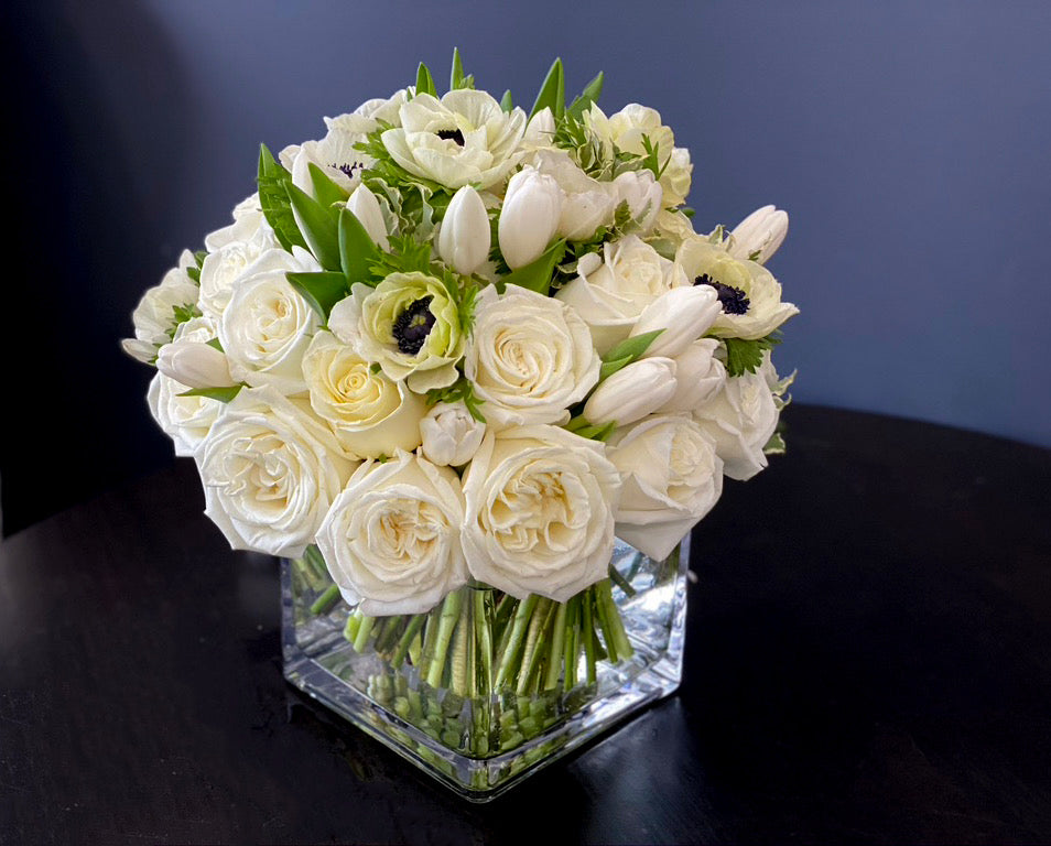 White roses tulips and anemones in clear glass vase