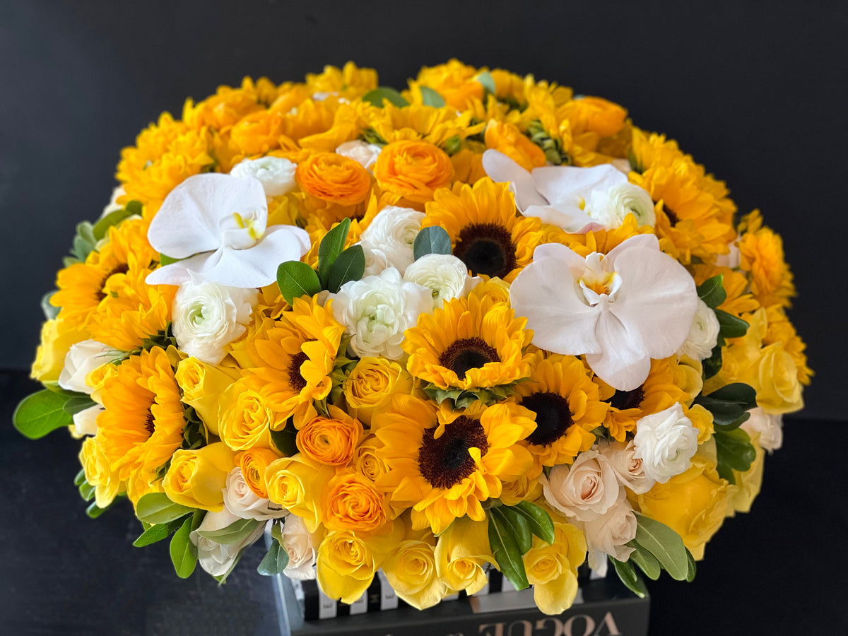Yellow roses sunflowers and white orchids flower arrangement