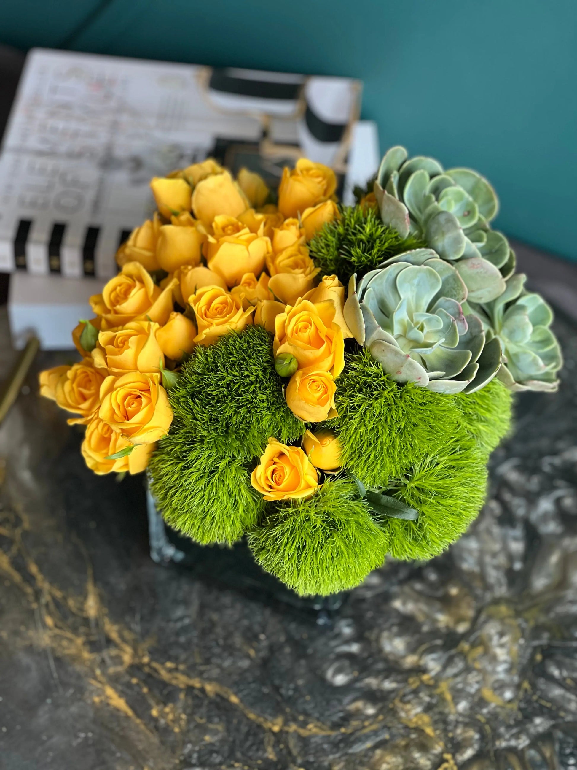 Yellow spray roses with decorative green balls and succulents