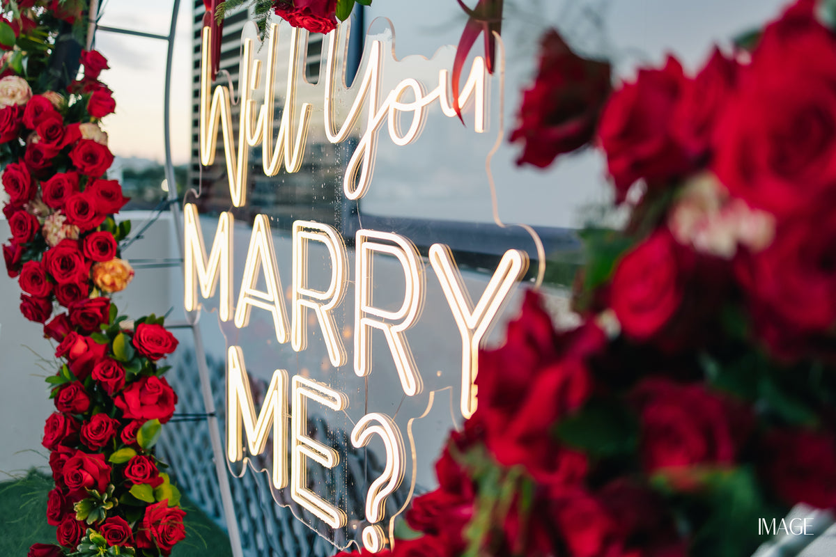Marry Me proposal setup in Miami with flowers, candles and MARRY ME letters