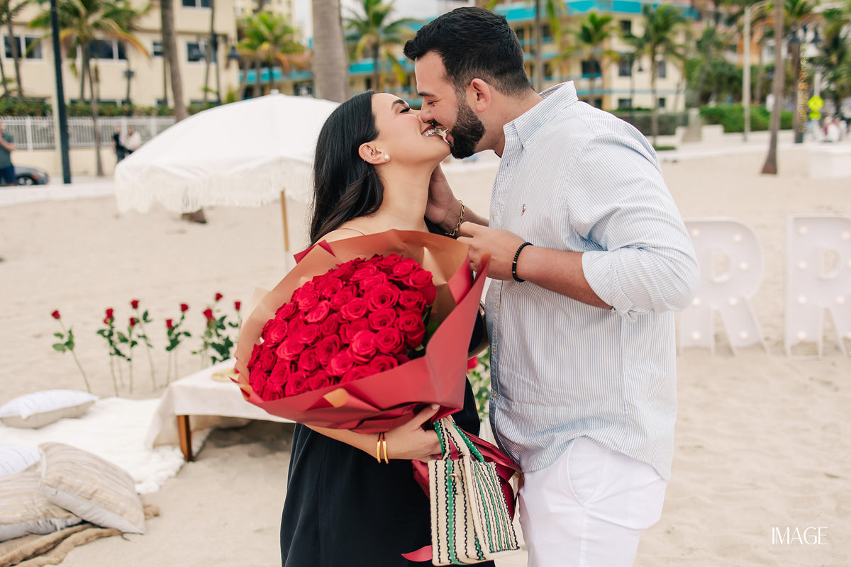 Grand Marry Me proposal setup in Miami with floral arch, roses and candles