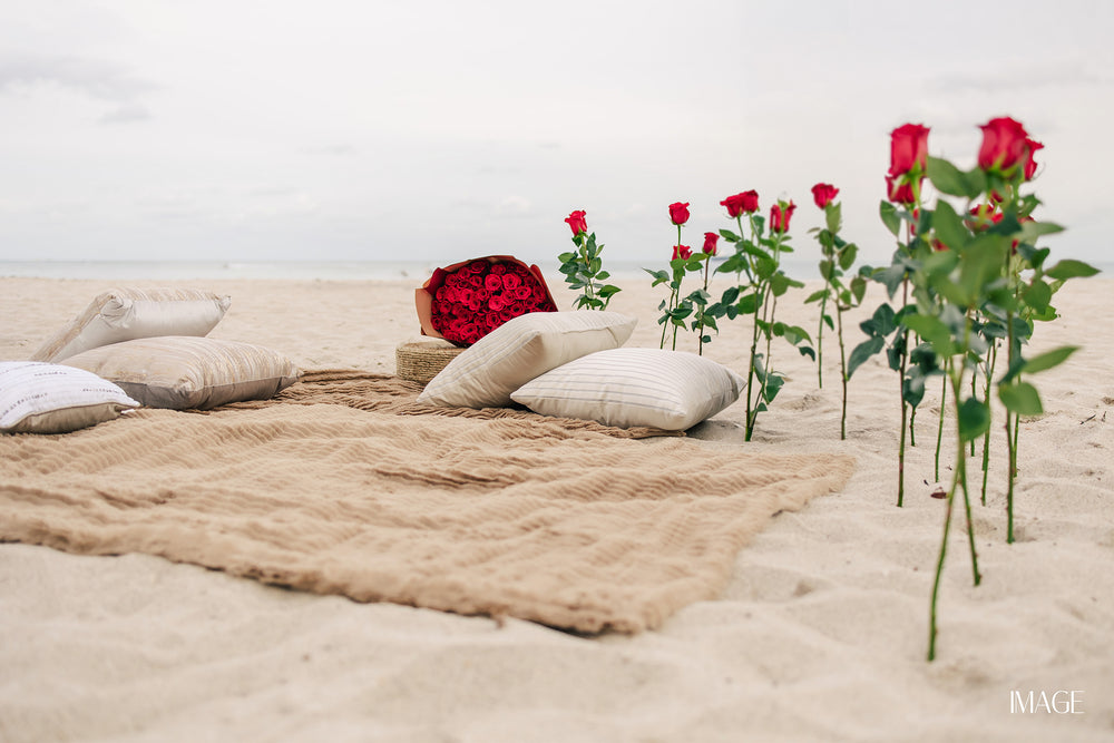 Romantic beach proposal setup in Miami with roses, candles and proposal decor