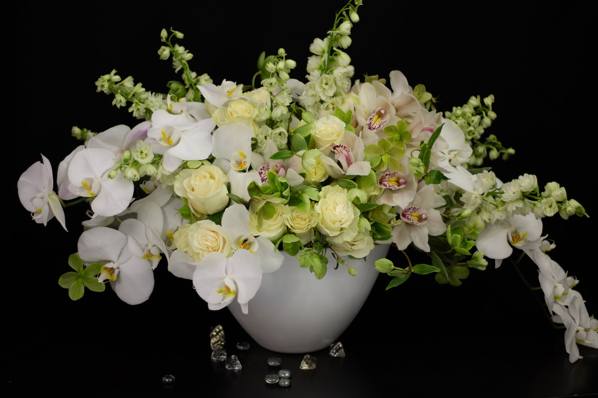 large white orchid and rose arrangement in ceramic vase
