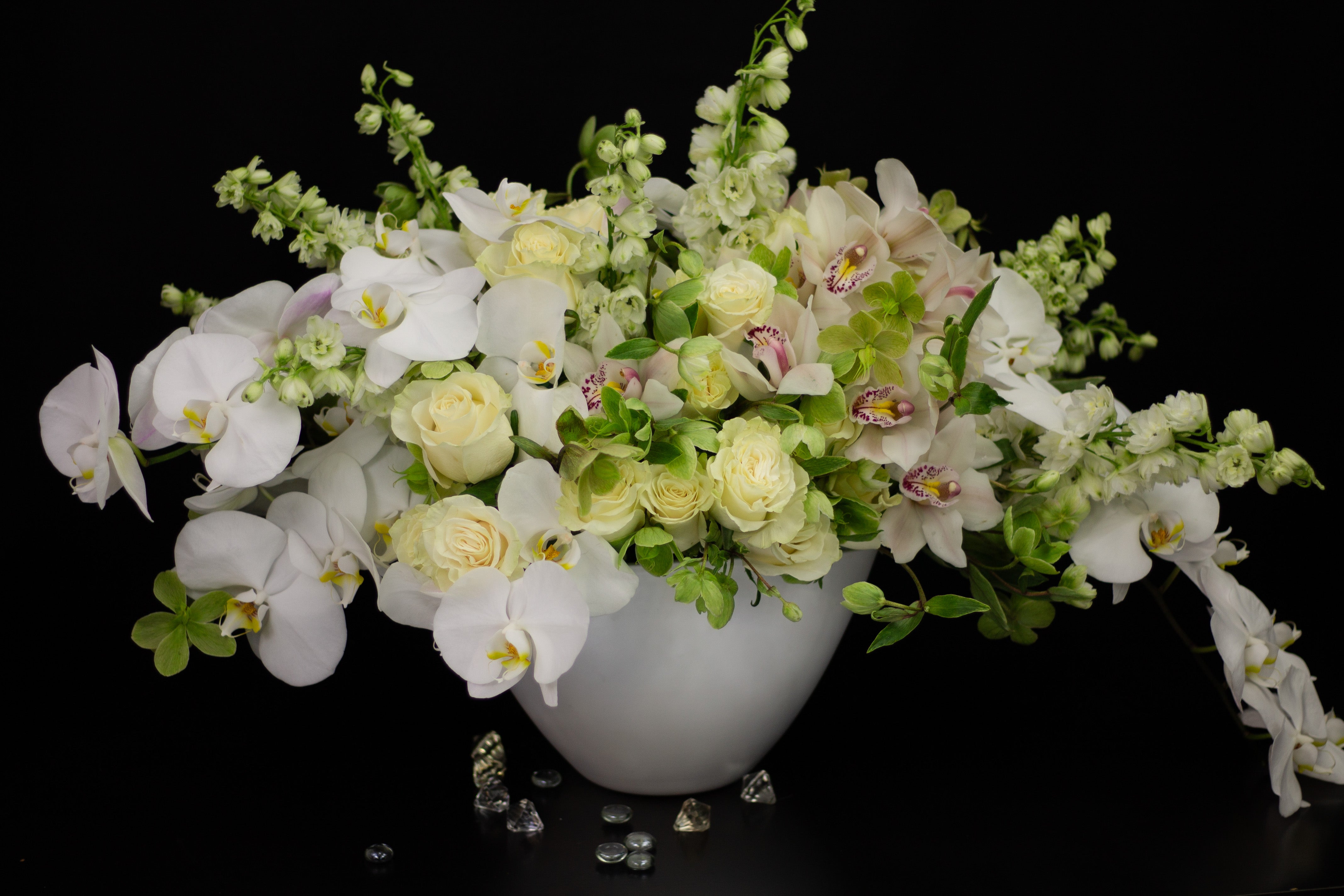large white orchid and rose arrangement in ceramic vase