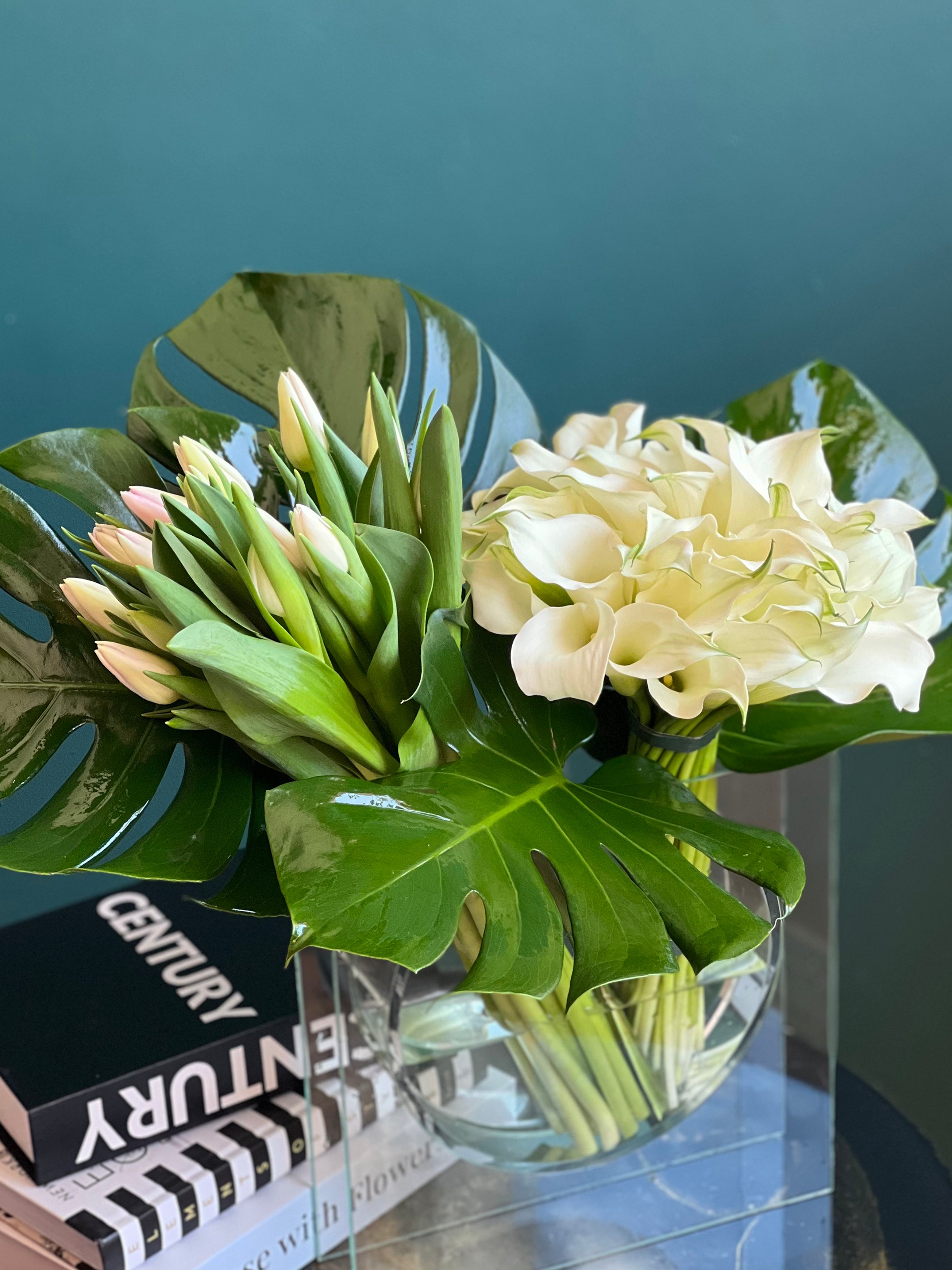 modern white tulip and calla lily flower arrangement in glass vase