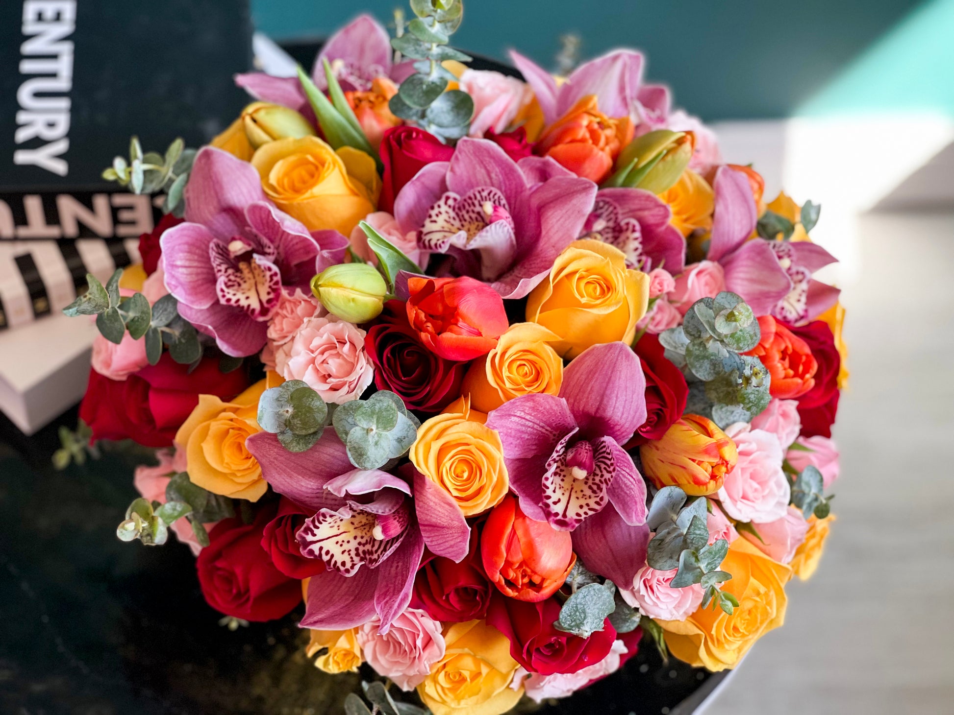 Bright Beauty is a luxury flower arrangement with garden roses, tulips, ranunculus, orchids, and premium roses in a gold vase. Same-day Miami flower delivery.